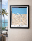 San Juan Puerto Rico framed 3D city map featuring white precision laser-cut street network, natural wood layers and blue ocean detail, showcased in a modern living room with sea view.