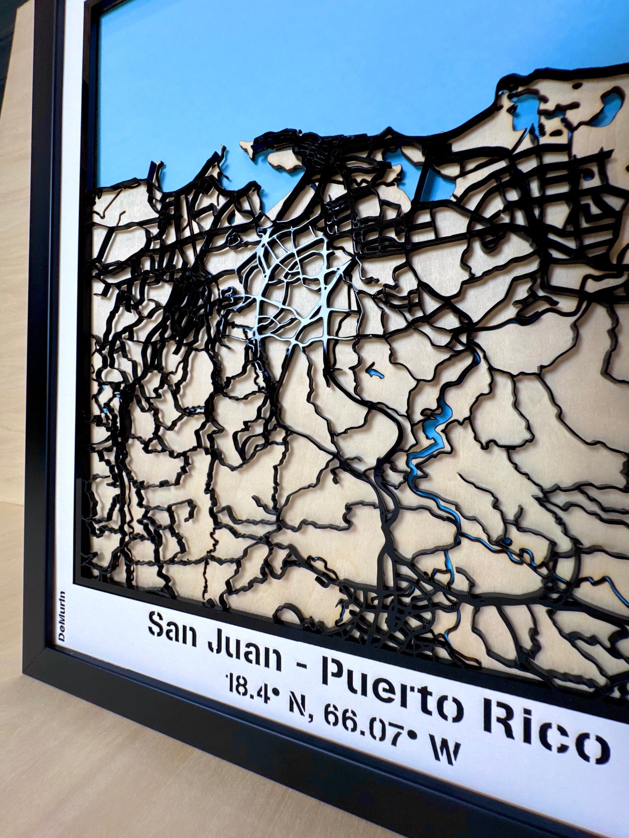 Detailed view of San Juan Puerto Rico framed 3D city map, laser-cut wooden street network with blue sea layer and engraved coordinates, handmade wall decor.